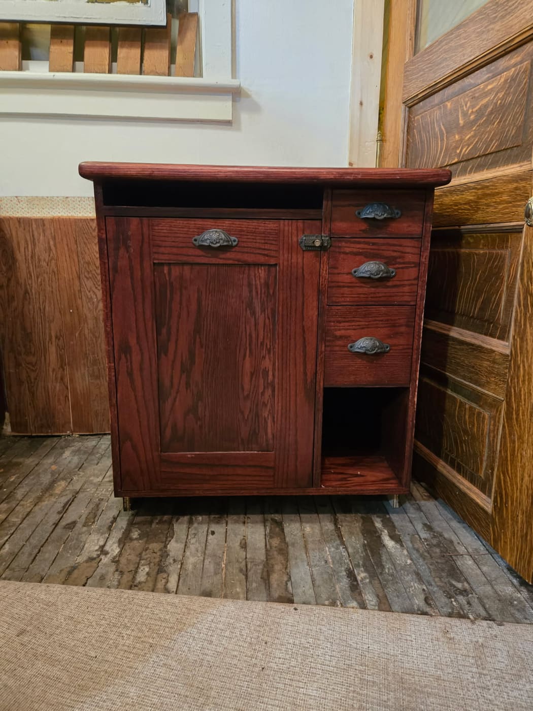 Hand-built oak cabinet finished in a deep red stain, fitted with antique cast bin pulls and a keyed latch